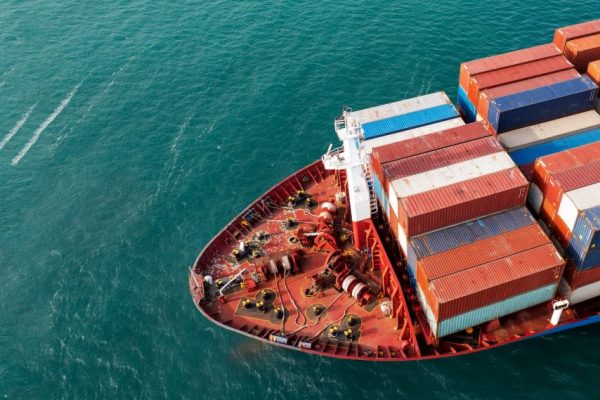 aerial-side-view-of-cargo-ship-carrying-container-and-running-for-export-goods-from-cargo-yard.jpg